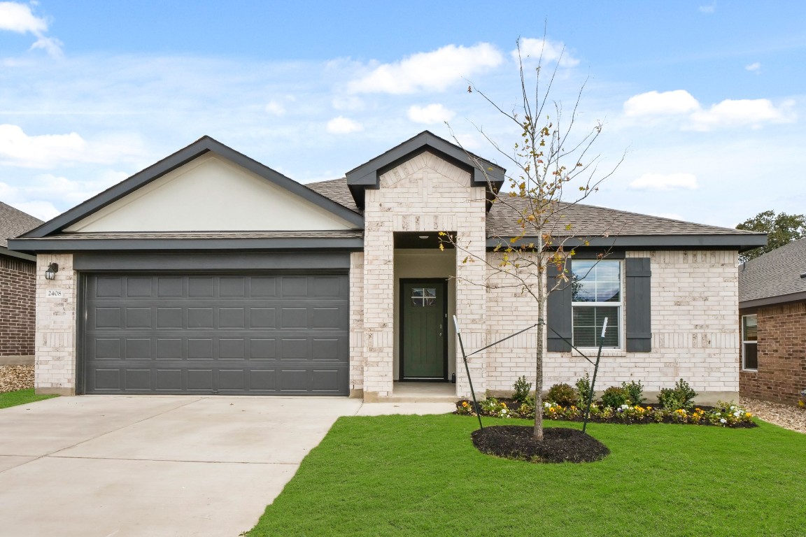 a front view of a house with a yard and garage