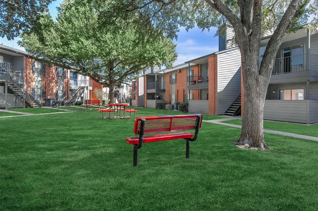 a white bench sitting in front of a house with a yard