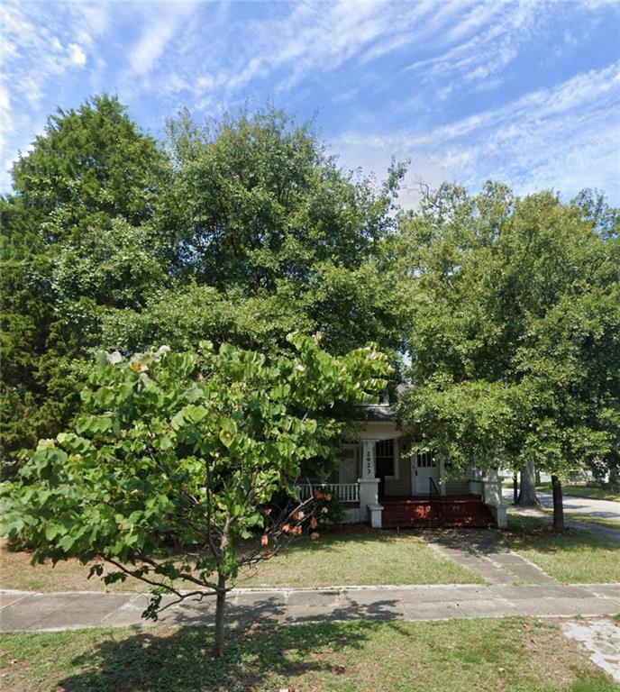 a view of a house with a yard and a tree