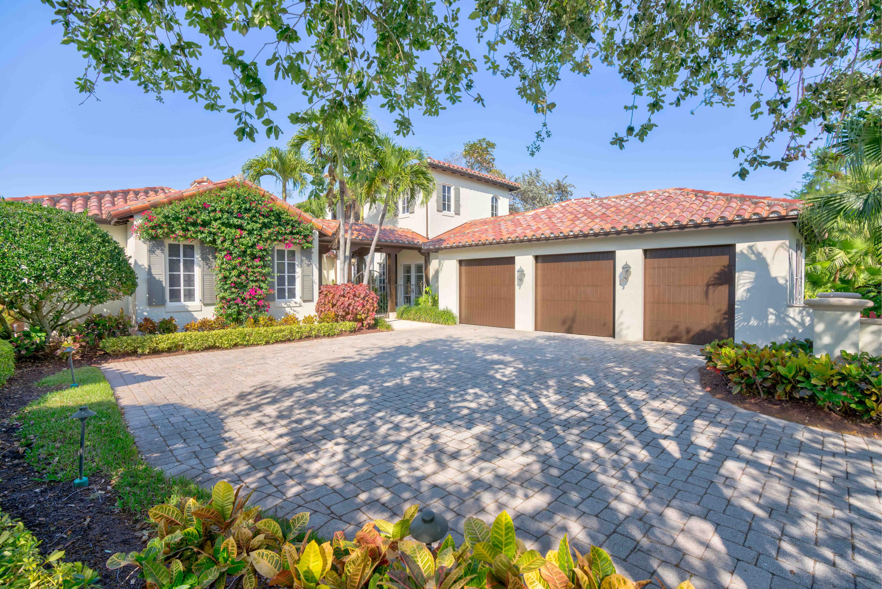 a front view of a house with a yard and a garden