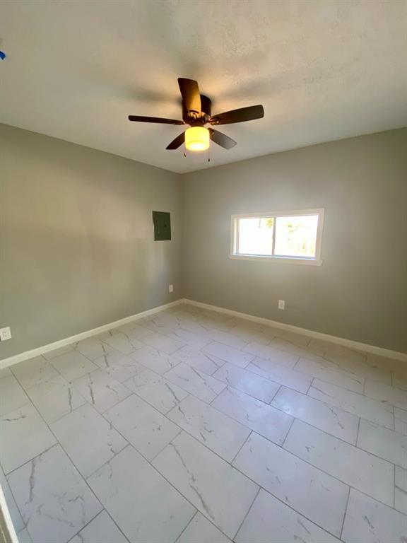 an empty room with windows and fan