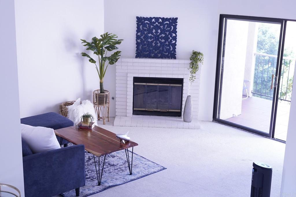 a living room with furniture a potted plant and a fireplace