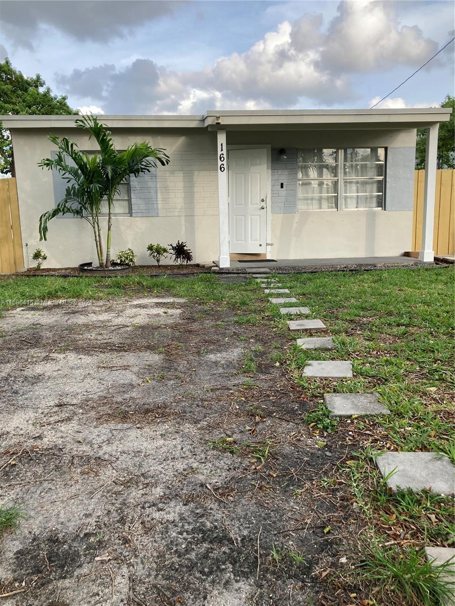 a front view of house with a garden