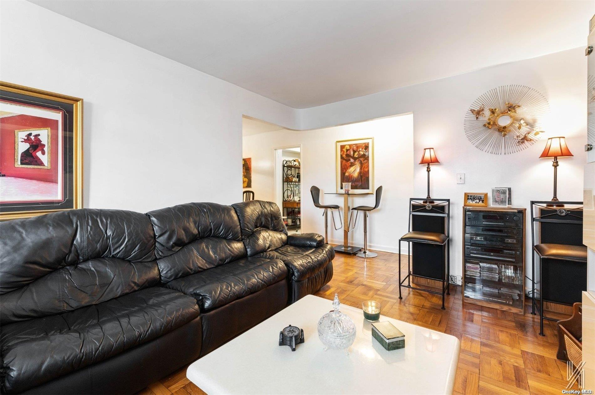 a living room with furniture kitchen view and a large window