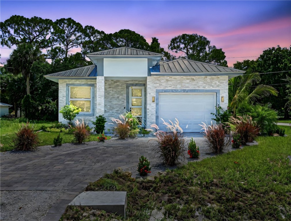 a front view of a house with a garden