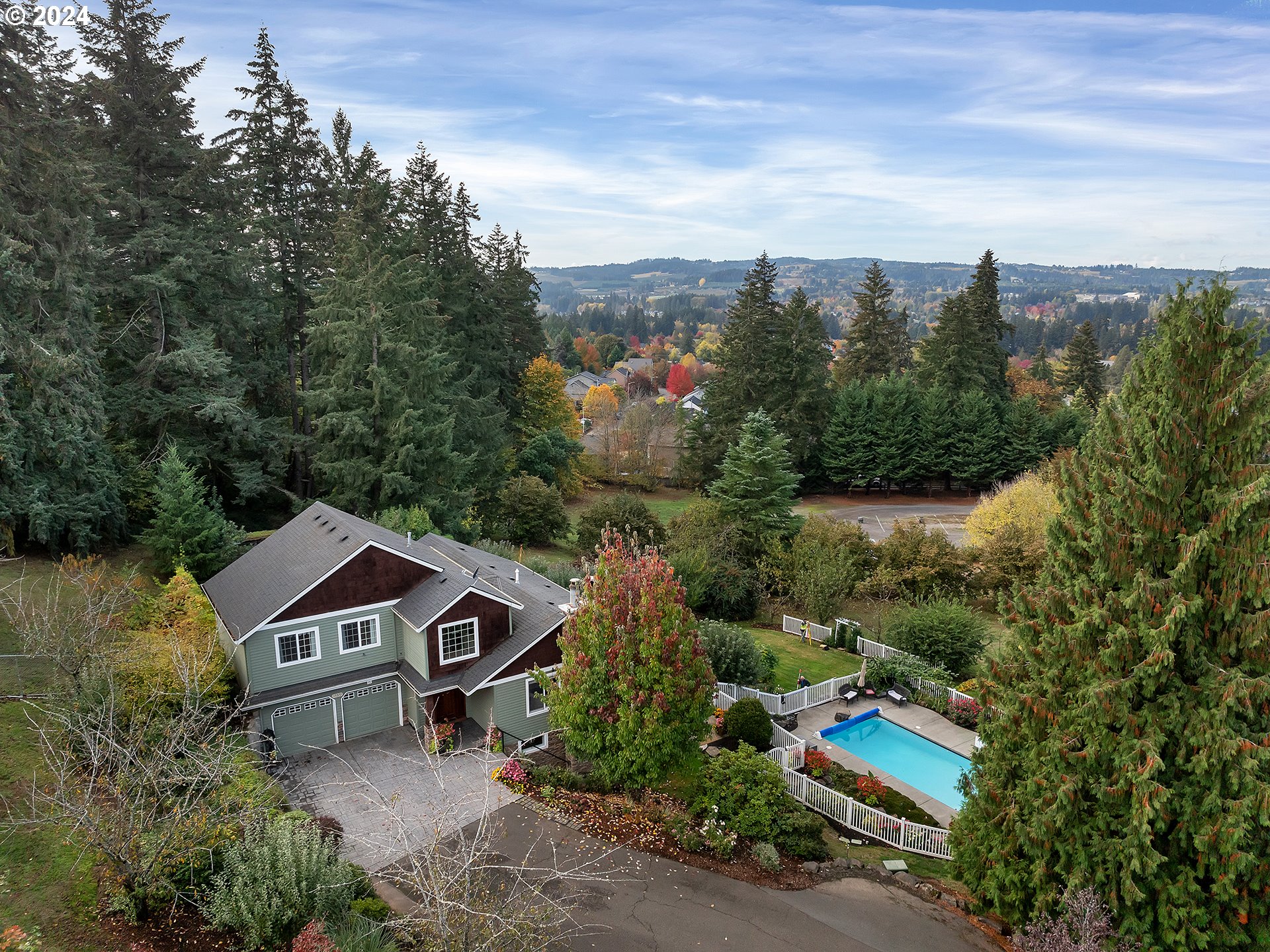 an aerial view of a house with a yard and large trees