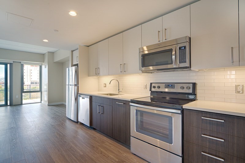 a kitchen with granite countertop cabinets stainless steel appliances and wooden floor