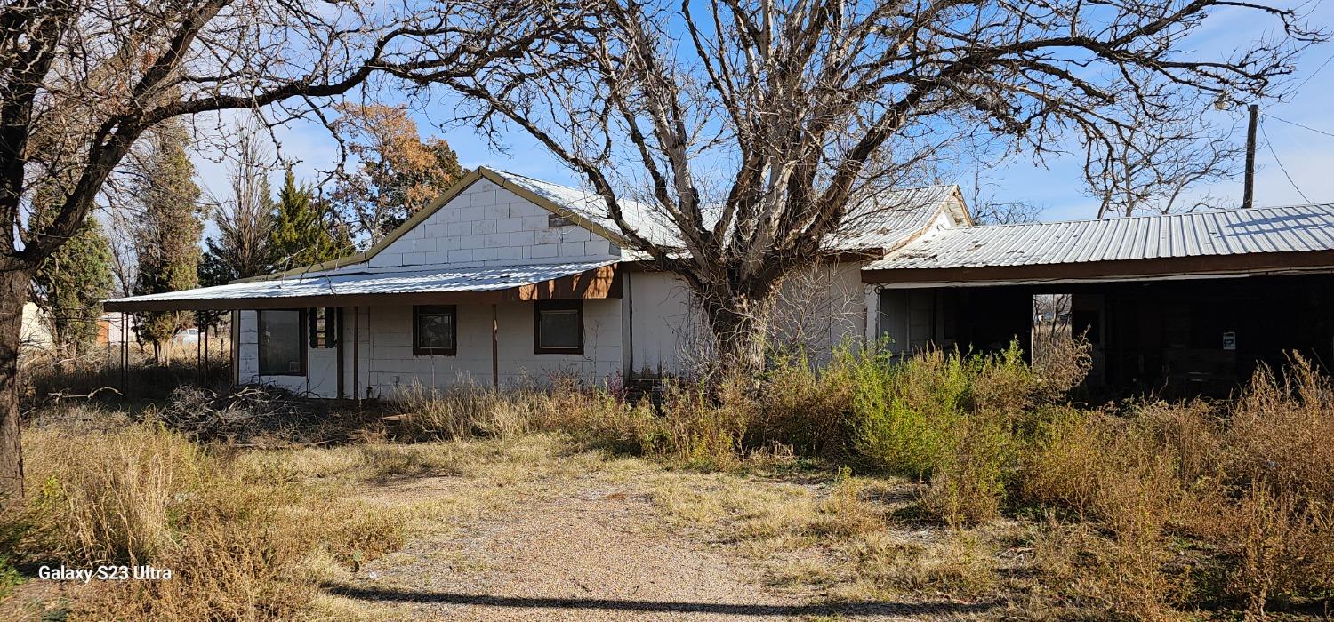 a front view of house with yard and trees around