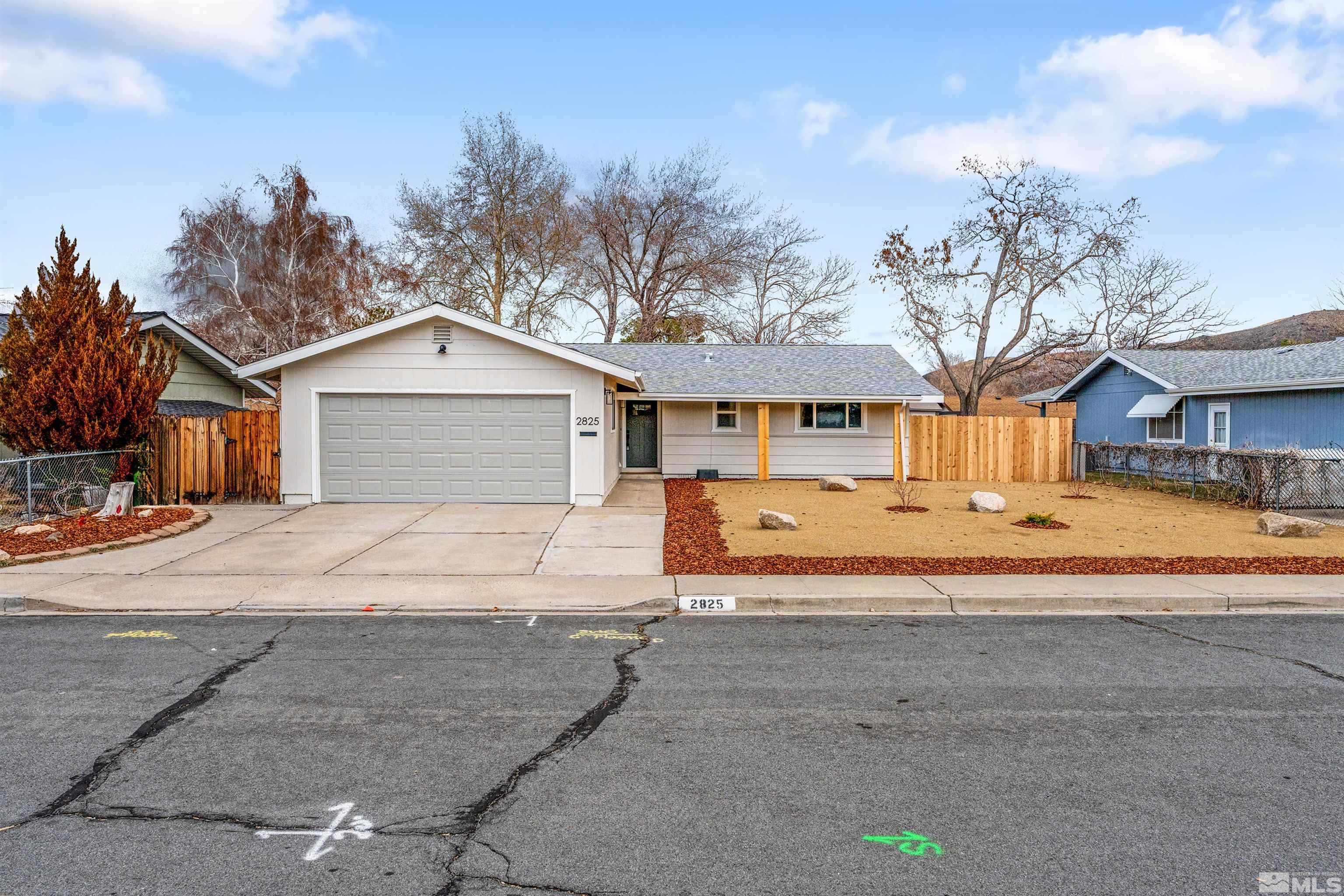 a front view of a house with a yard and parking space