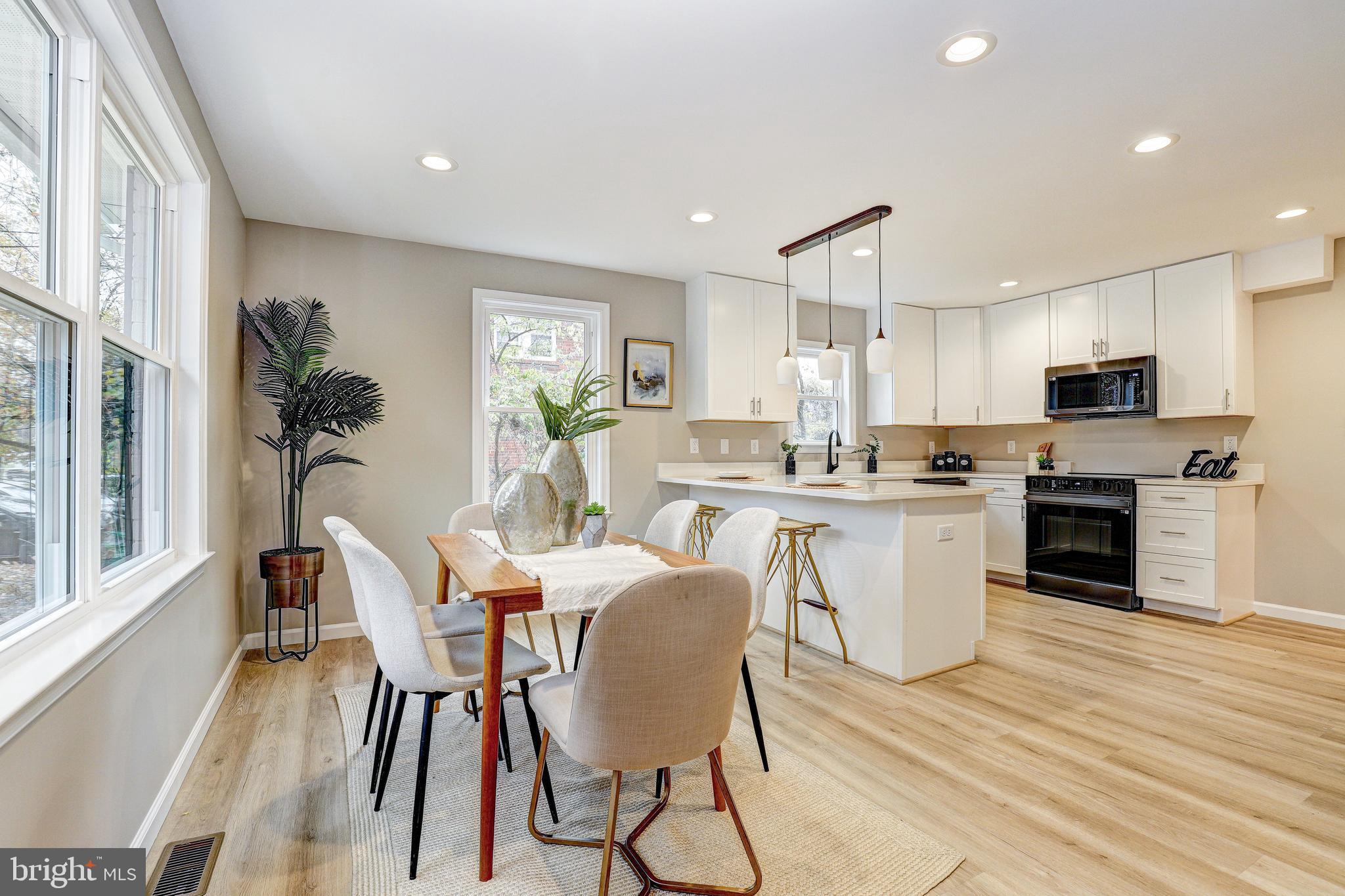 a kitchen with a table chairs refrigerator and microwave