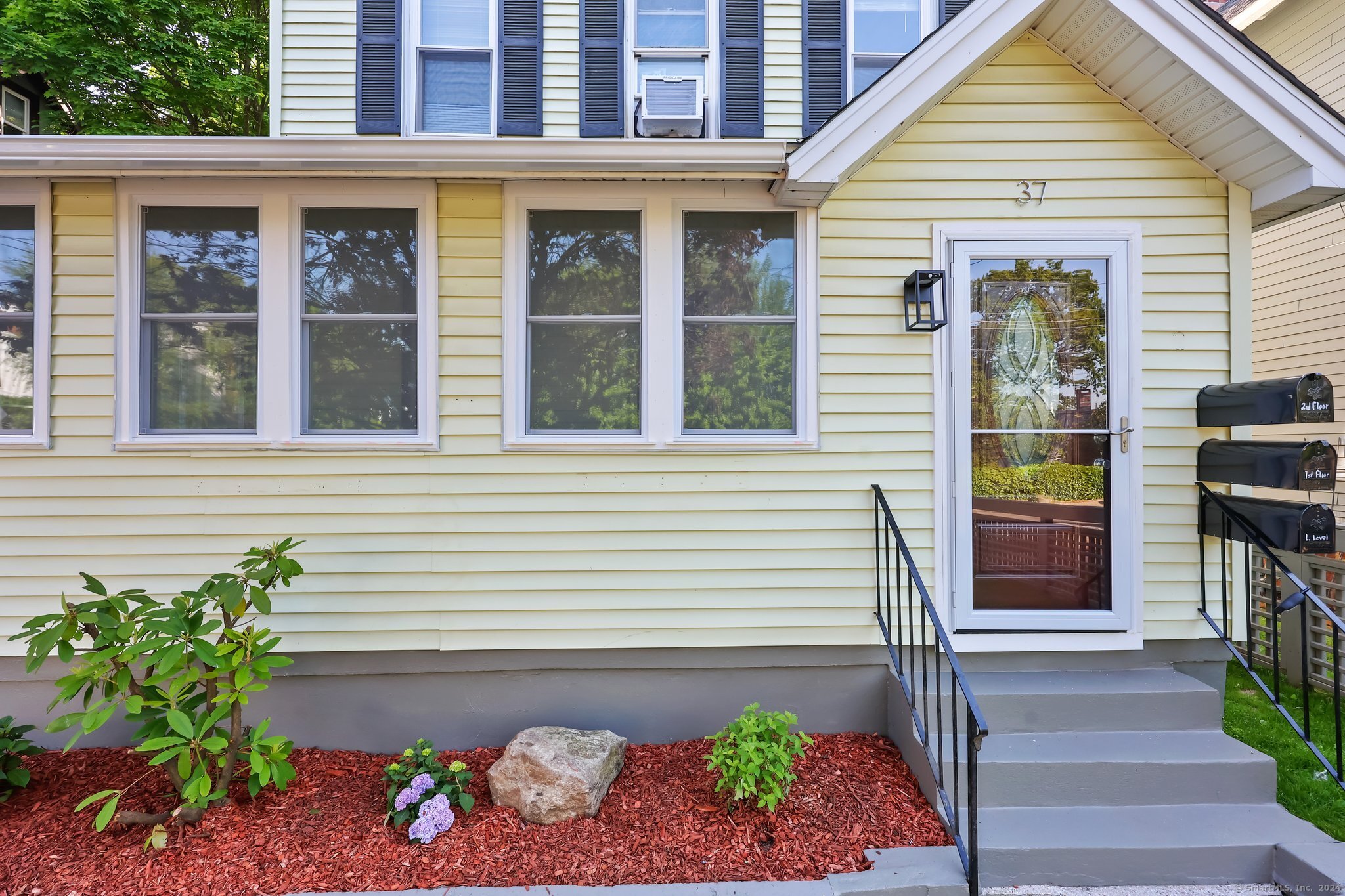 a front view of a house with a garden