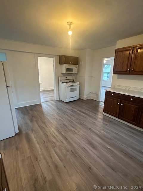 a view of a kitchen with wooden floor and electronic appliances