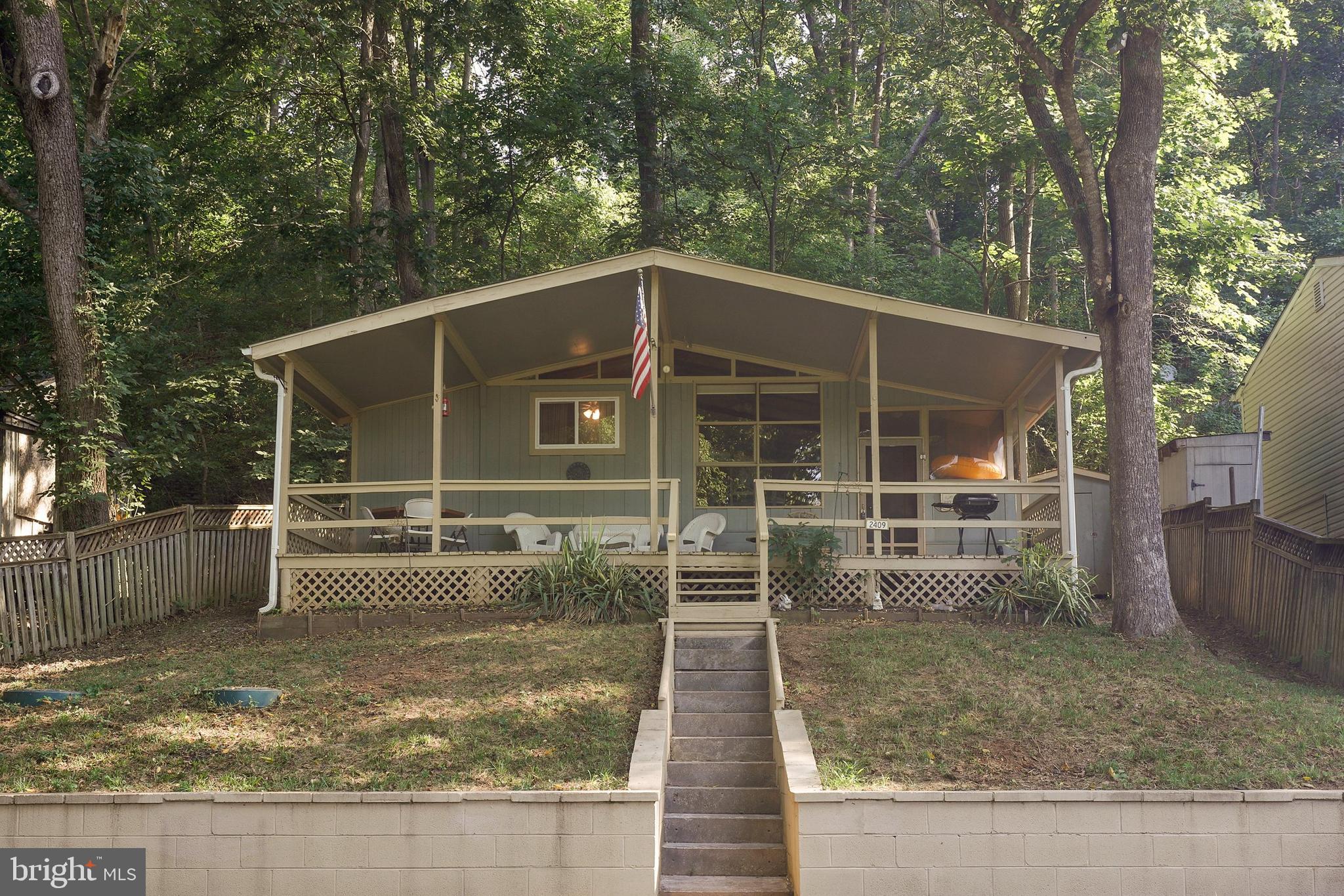 a view of house with a small yard and large tree