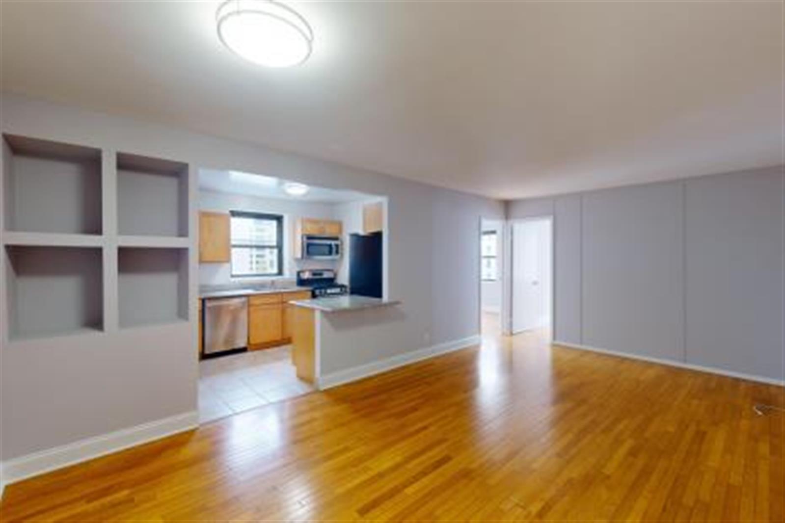 a large kitchen with stainless steel appliances granite countertop a stove and a wooden floors