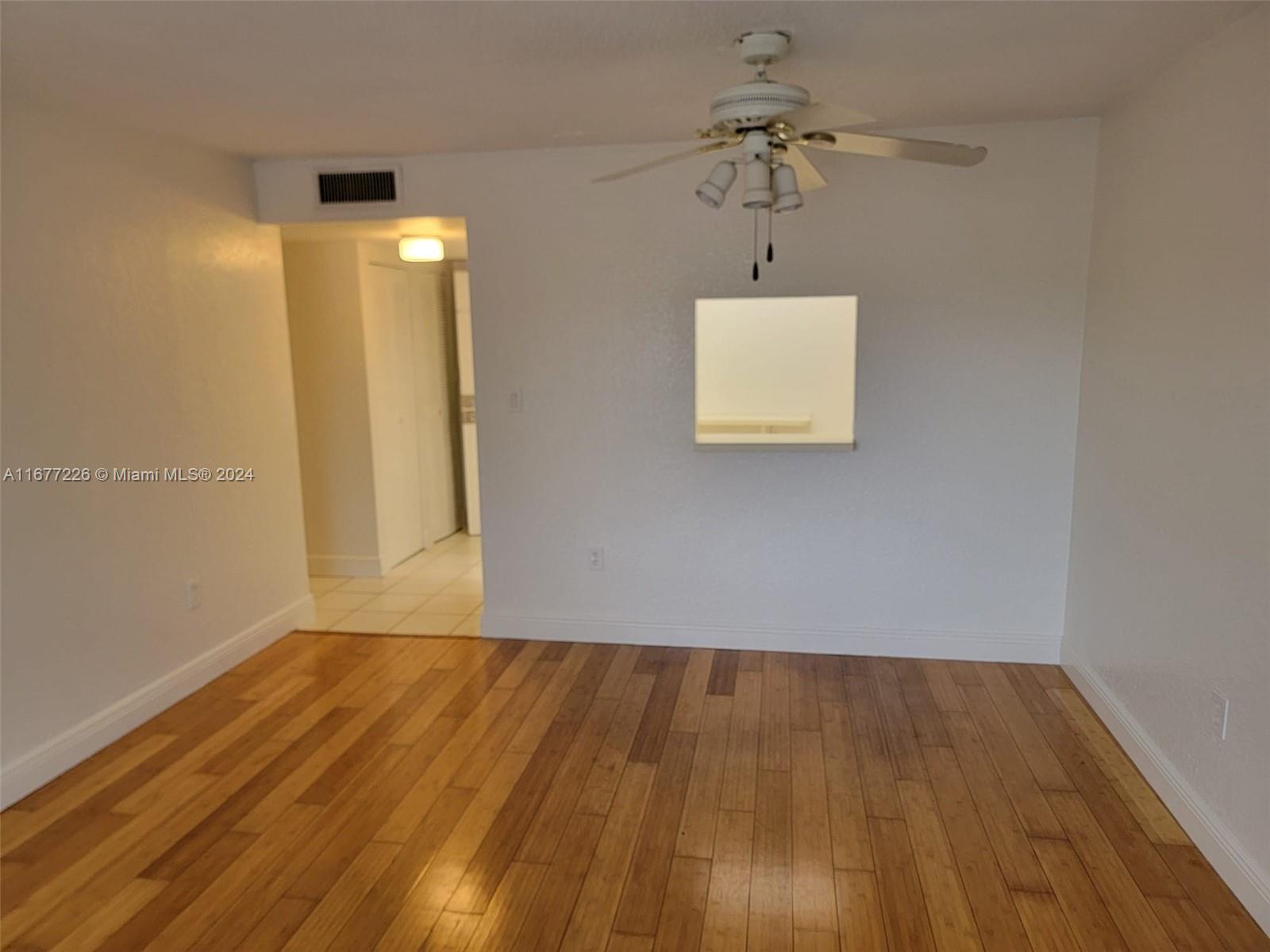 a view of room with wooden floor and ceiling fan