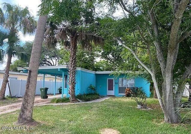 a front view of a house with a yard and an tree