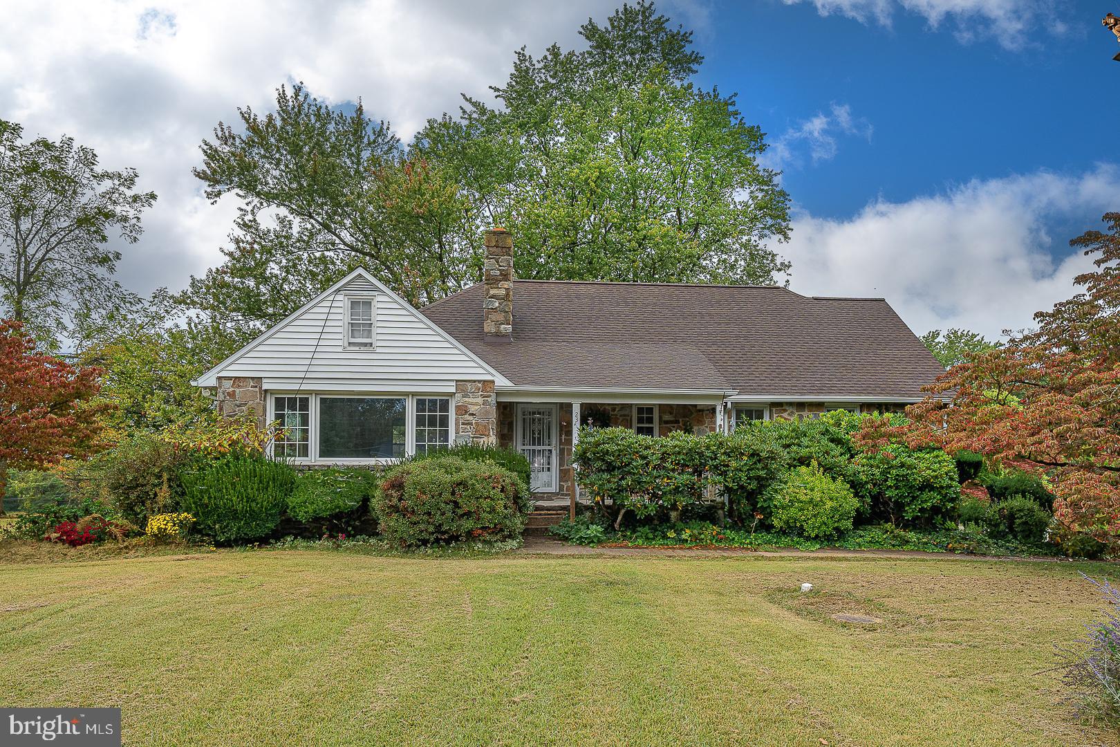 a front view of a house with a yard and trees