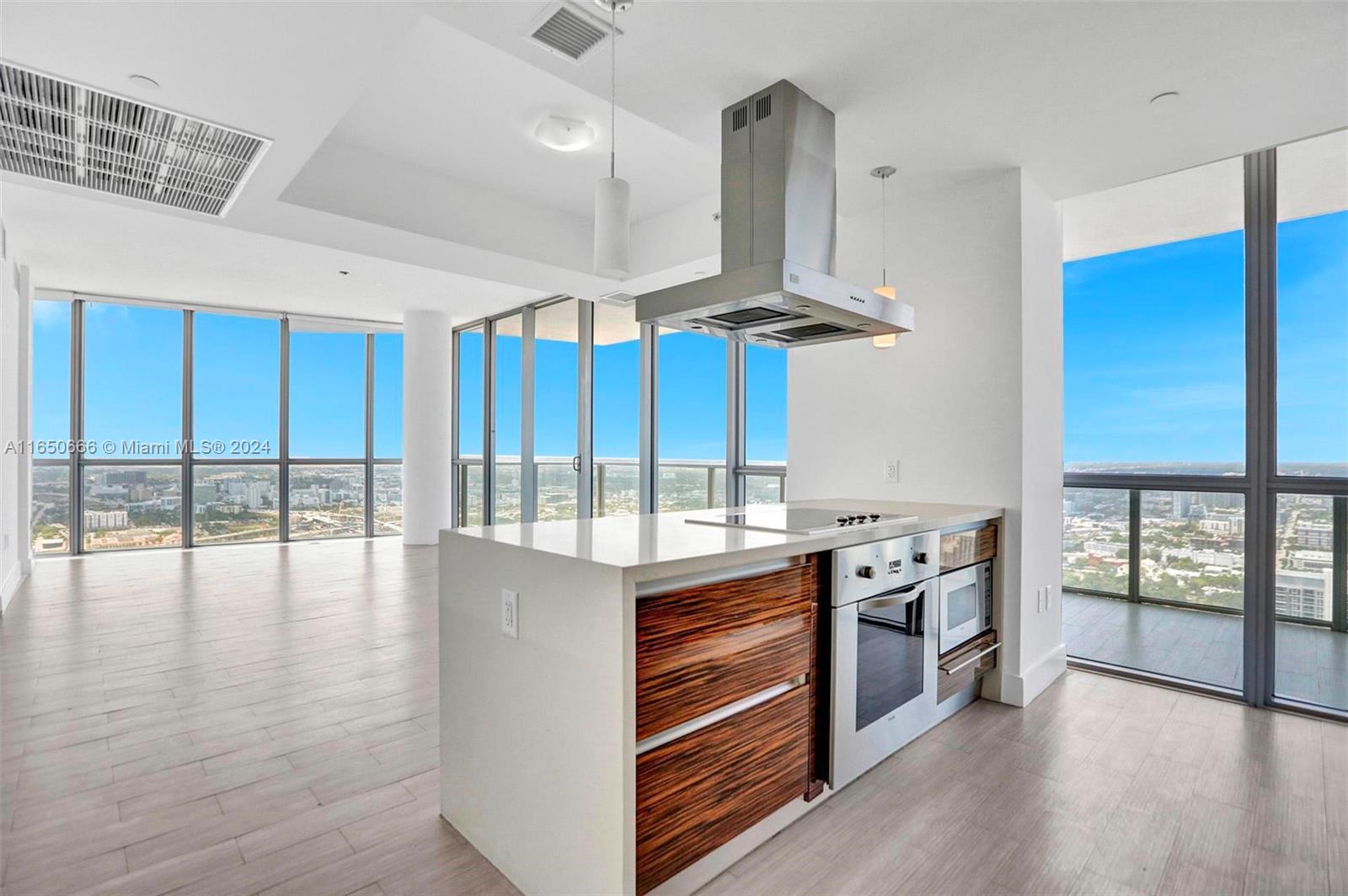 a kitchen with stainless steel appliances a stove and wooden floor