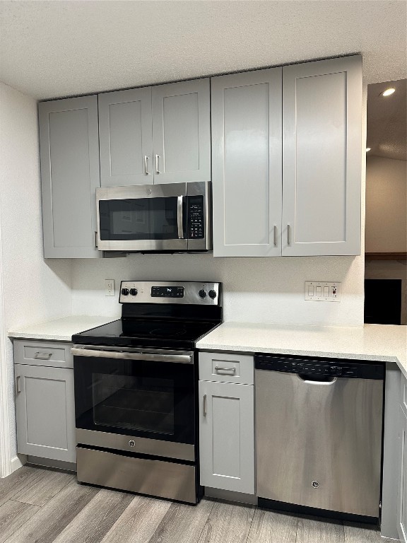 a kitchen with granite countertop cabinets stainless steel appliances and wooden floor