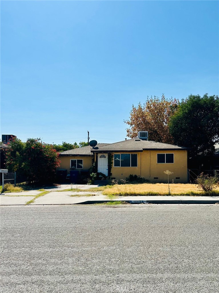 a front view of a house with a yard and trees