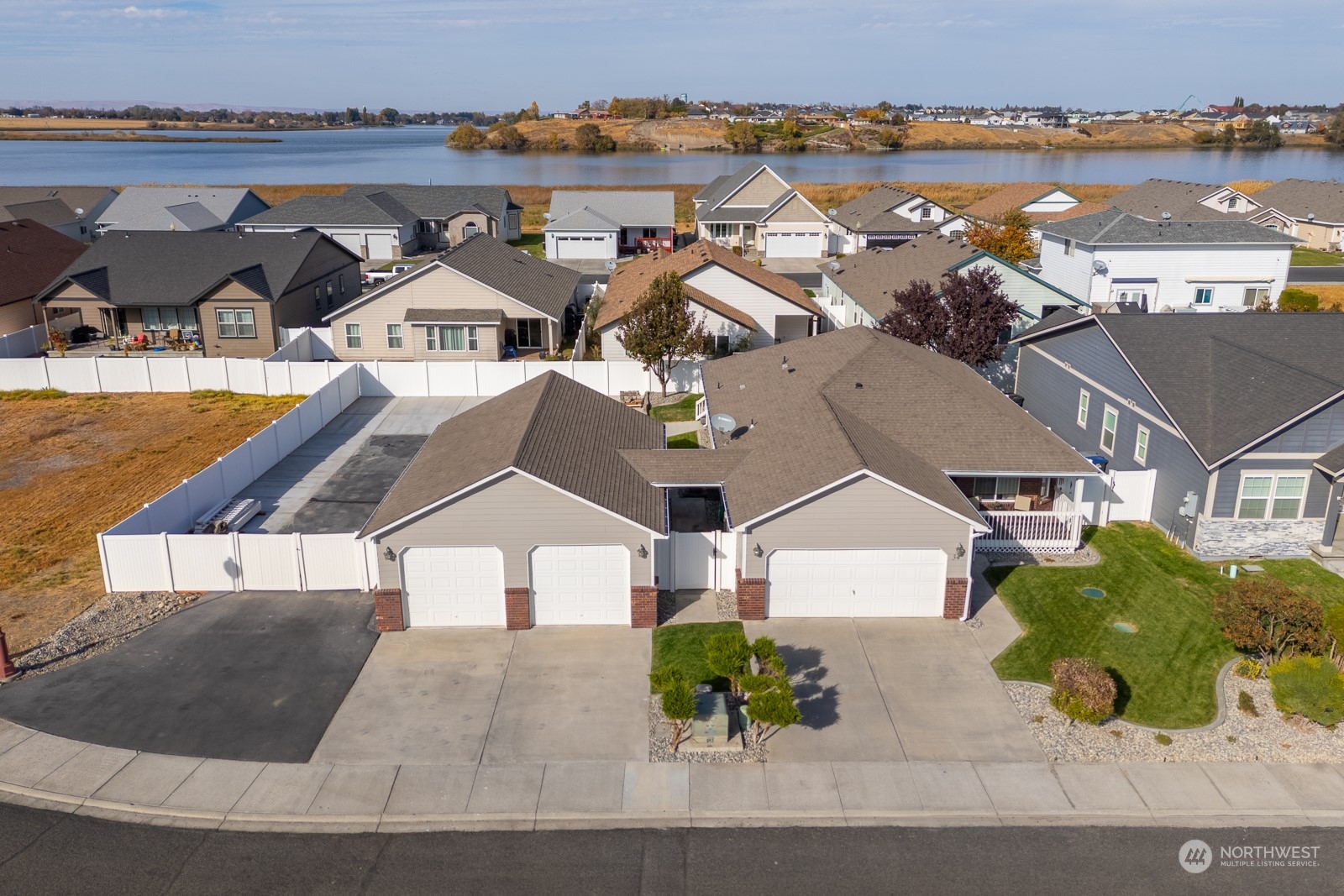 an aerial view of a house with a yard and lake view