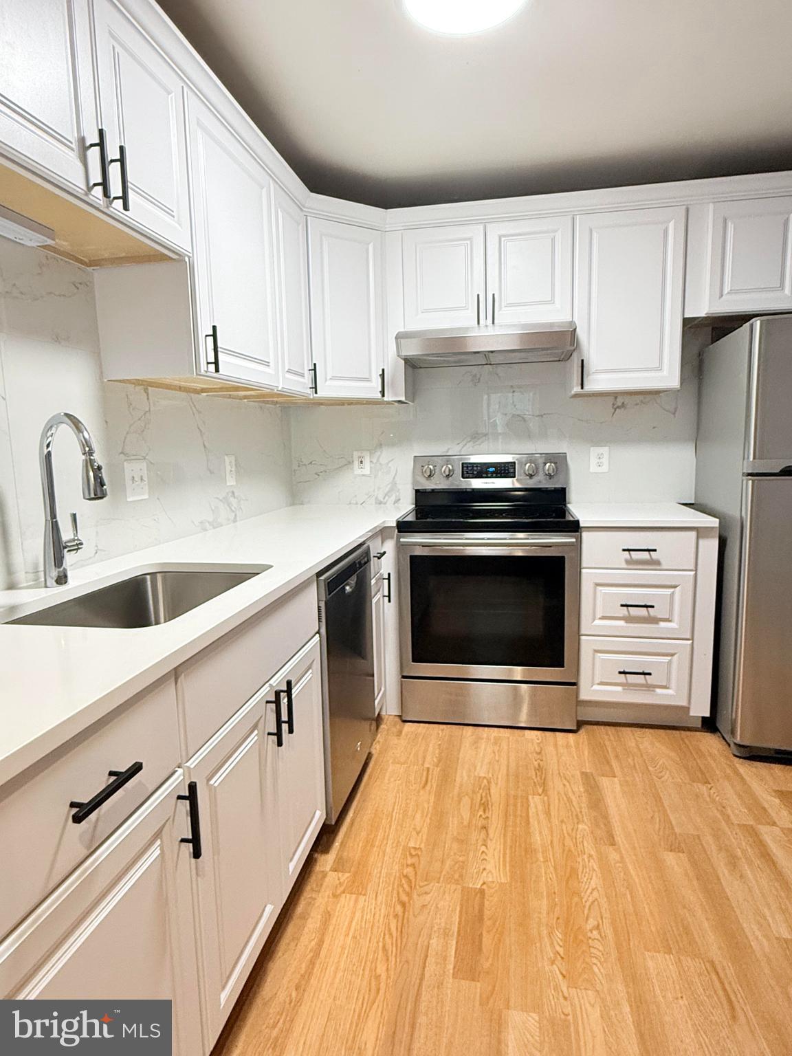 a kitchen with stainless steel appliances a stove sink and cabinets