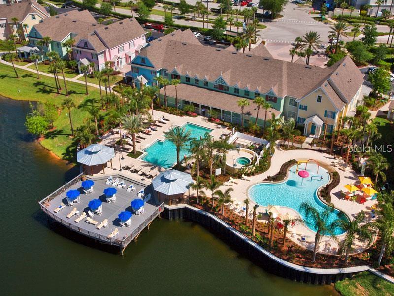 an aerial view of a house with a lake boats and trees all around