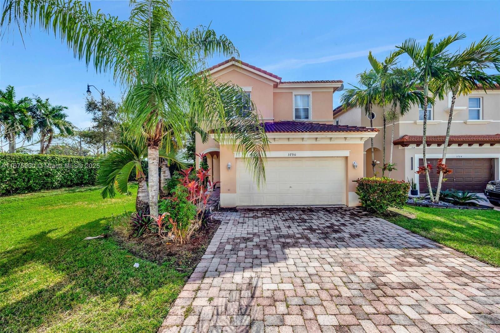 a white house with a yard and a palm tree