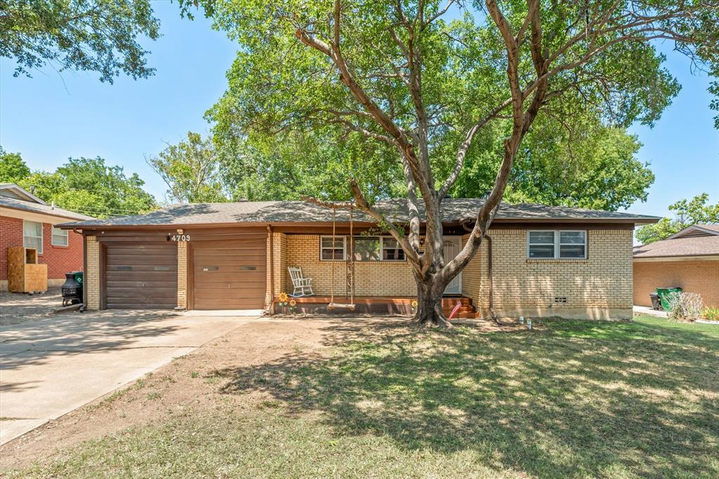 a view of a house with backyard and tree