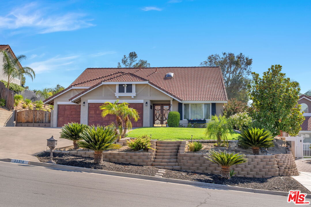 a front view of a house with a garden