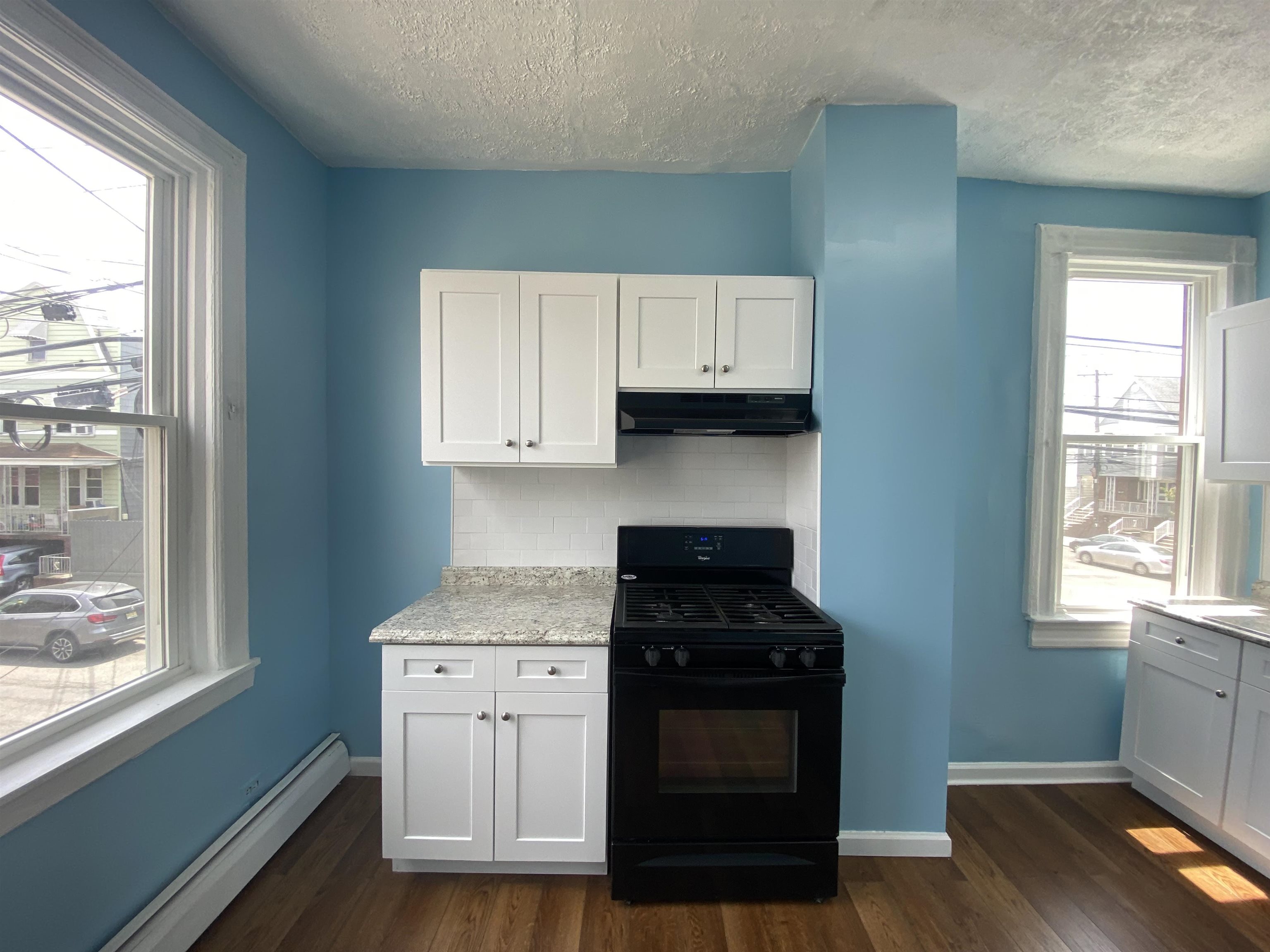 a kitchen with appliances cabinets and a wooden floor