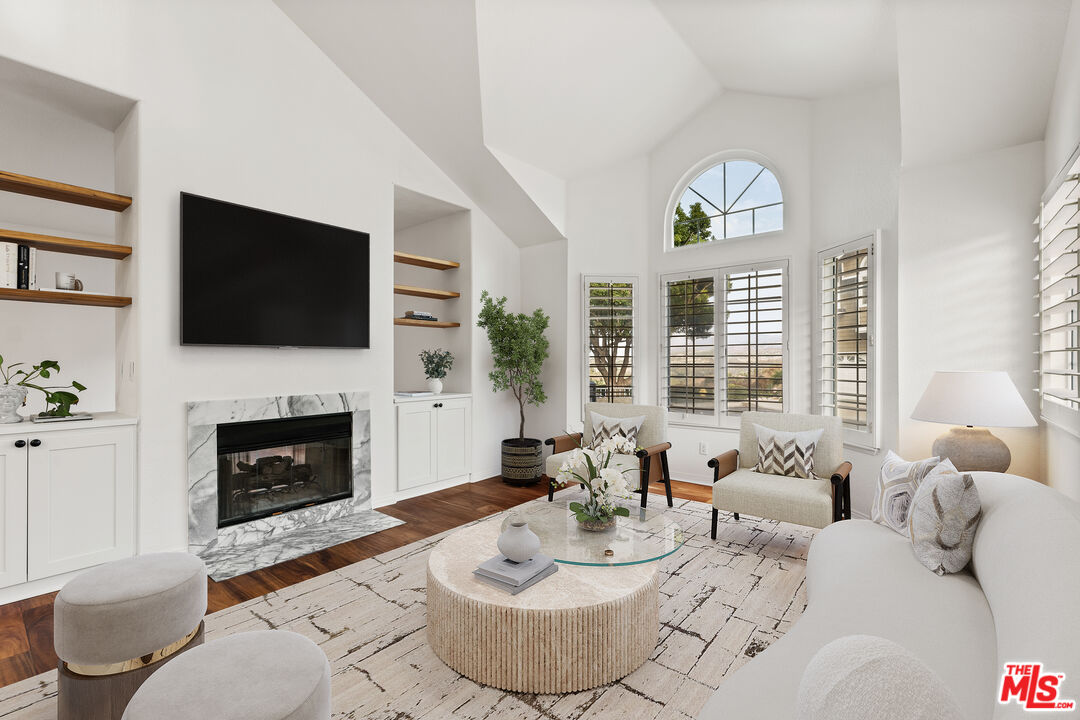 a living room with furniture a fireplace and a flat screen tv