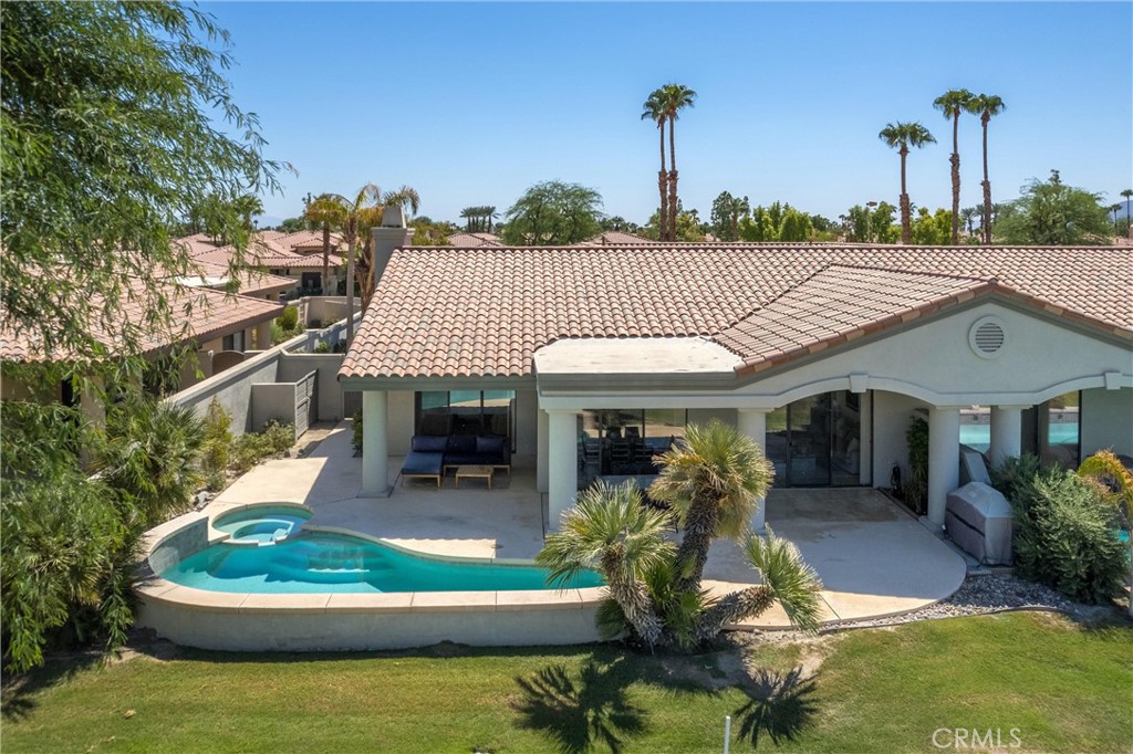 a view of a house with backyard swimming pool and outdoor seating