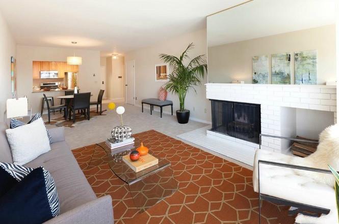 a living room with furniture a fireplace and a dining table with wooden floor