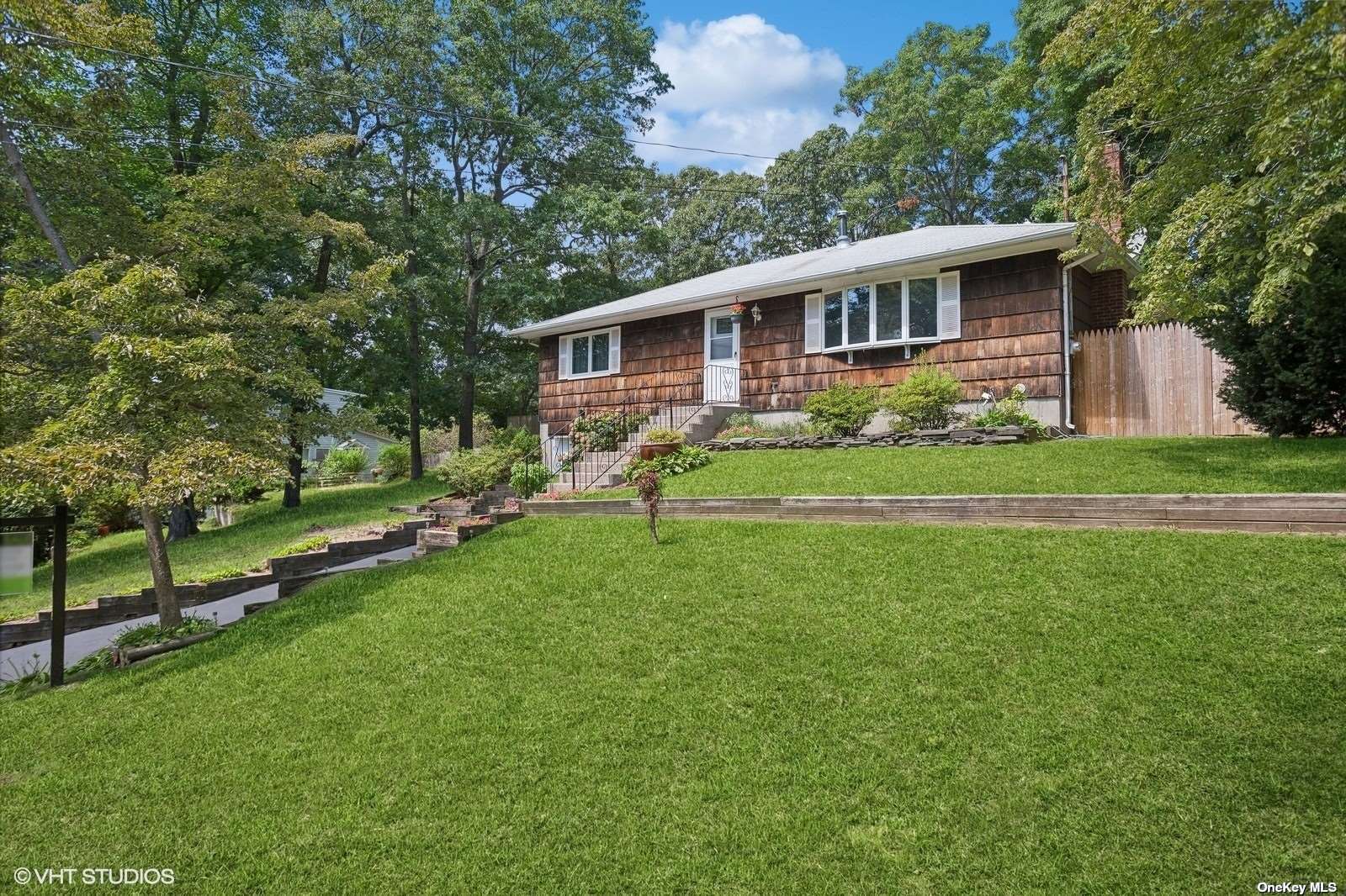 a front view of a house with a yard and trees