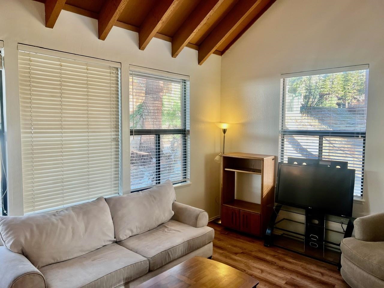 a living room with furniture a flat screen tv and a window