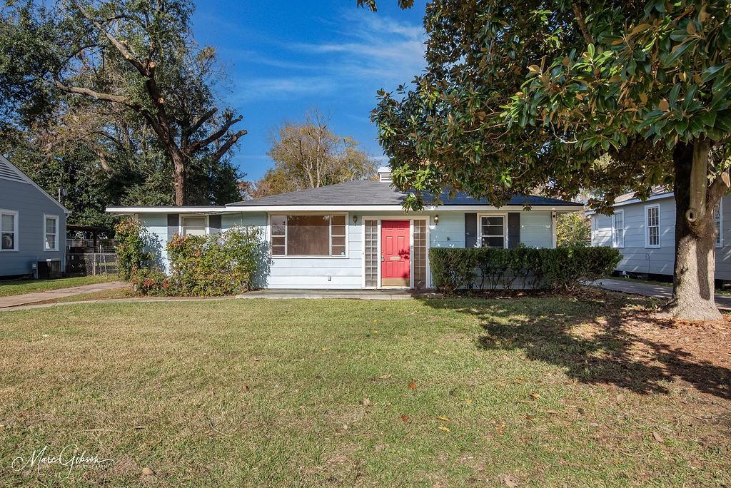 a view of a house with a yard and tree