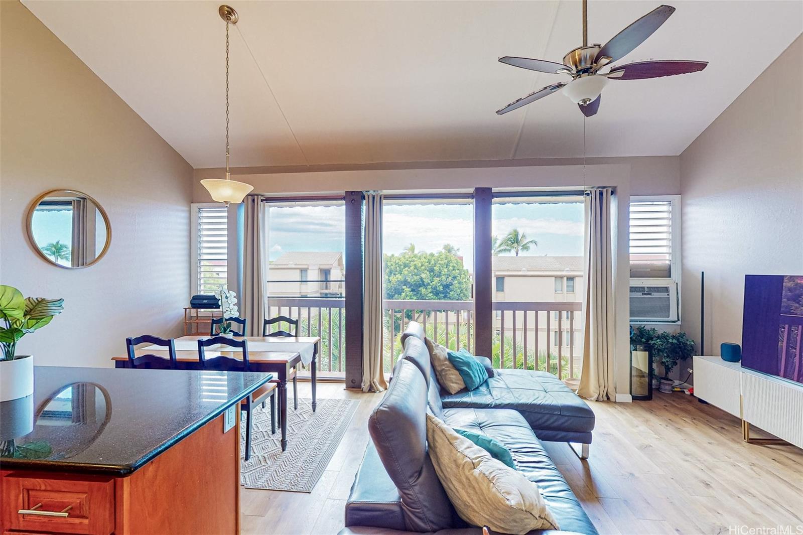 a living room with furniture a ceiling fan and a large window