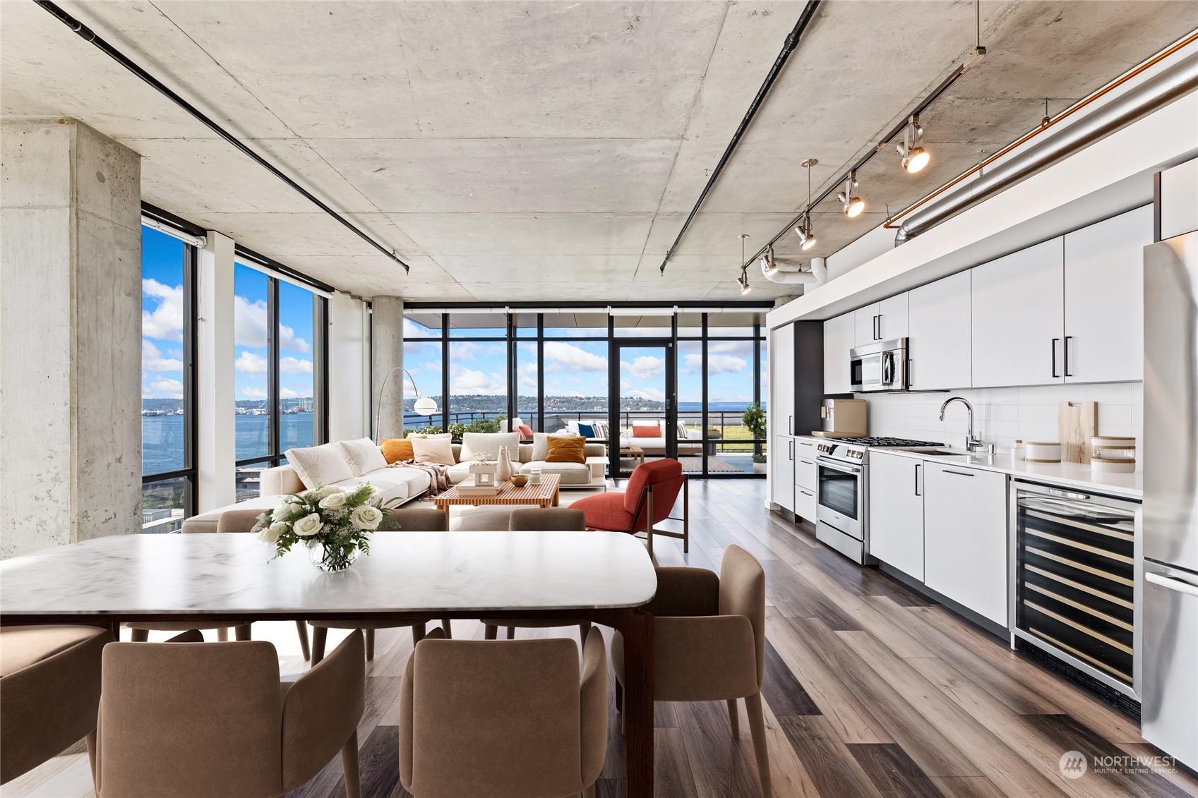 a living room with stainless steel appliances granite countertop furniture and a large window