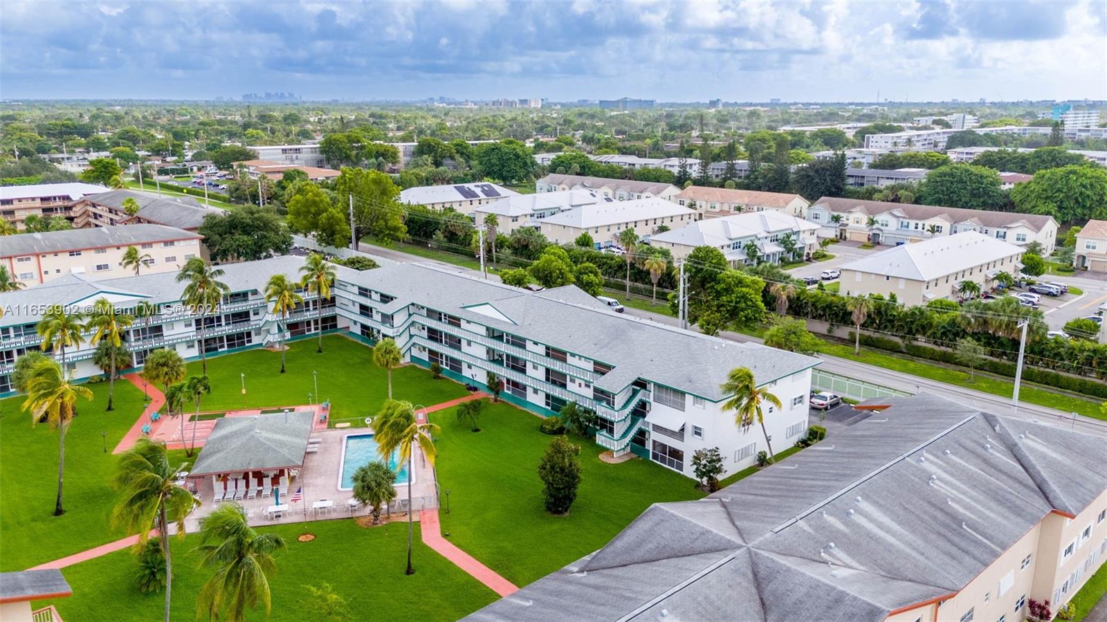 an aerial view of a city with lots of residential buildings ocean and mountain view in back