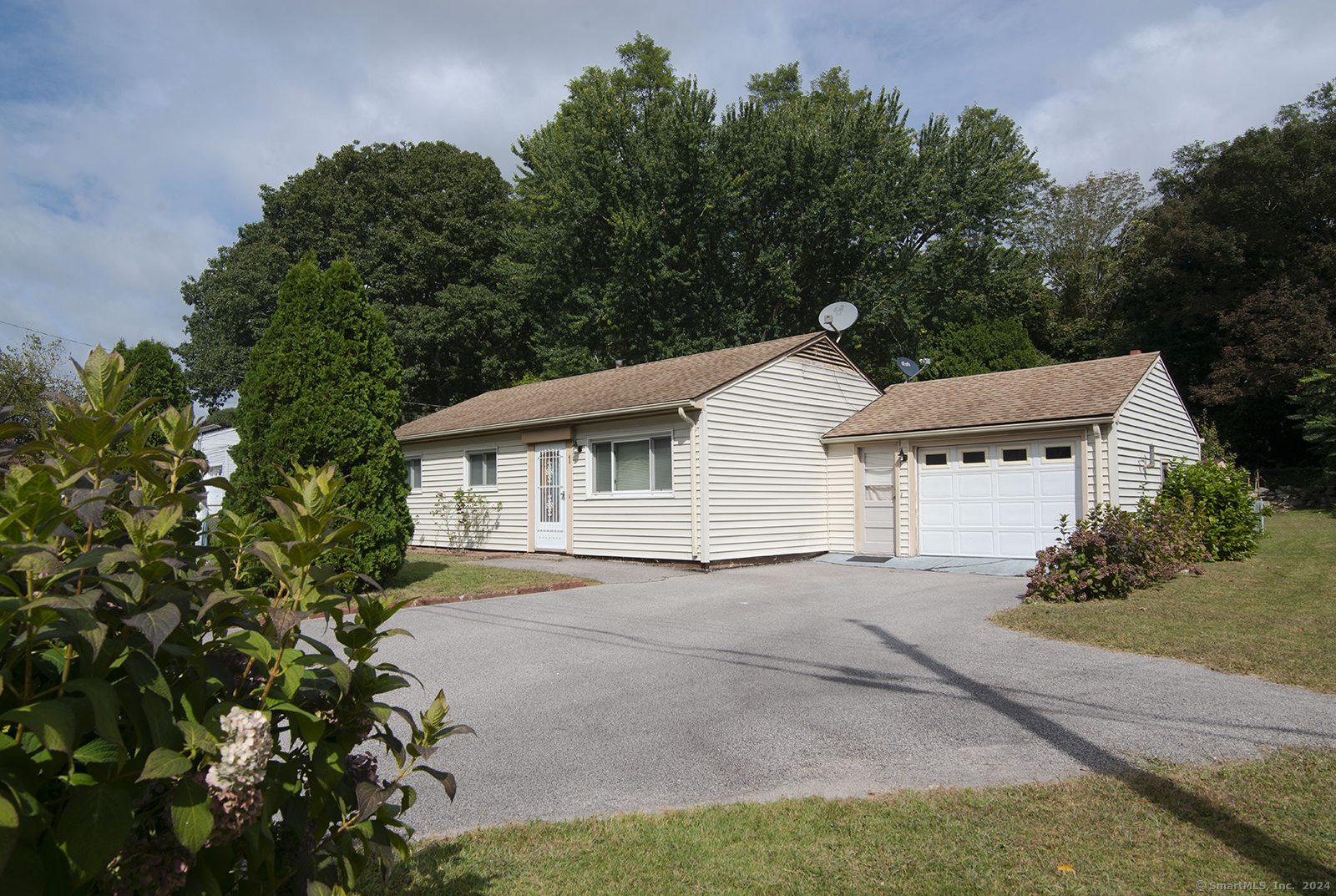 a view of a house with a yard and large tree