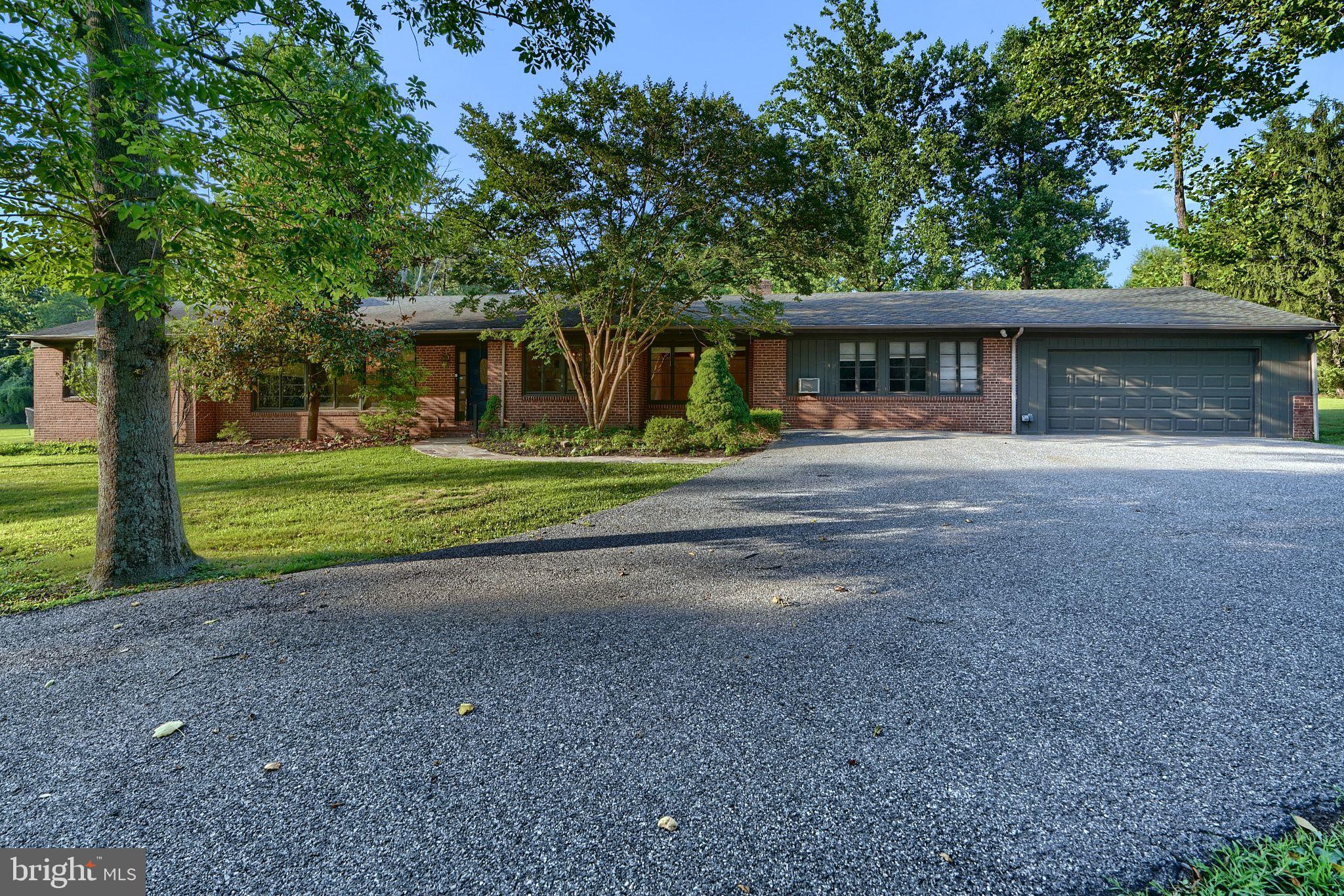 a front view of a house with a yard and trees