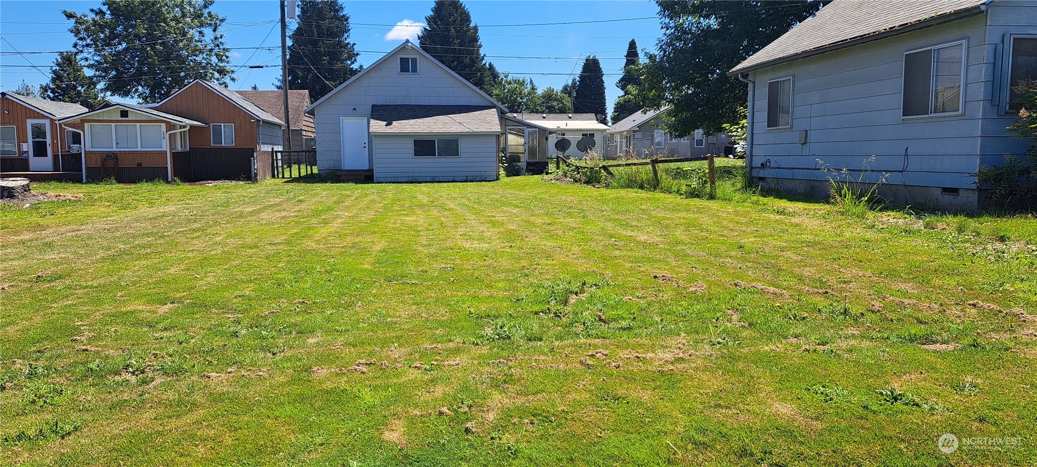 a view of a yard in front of a brick house with a big yard