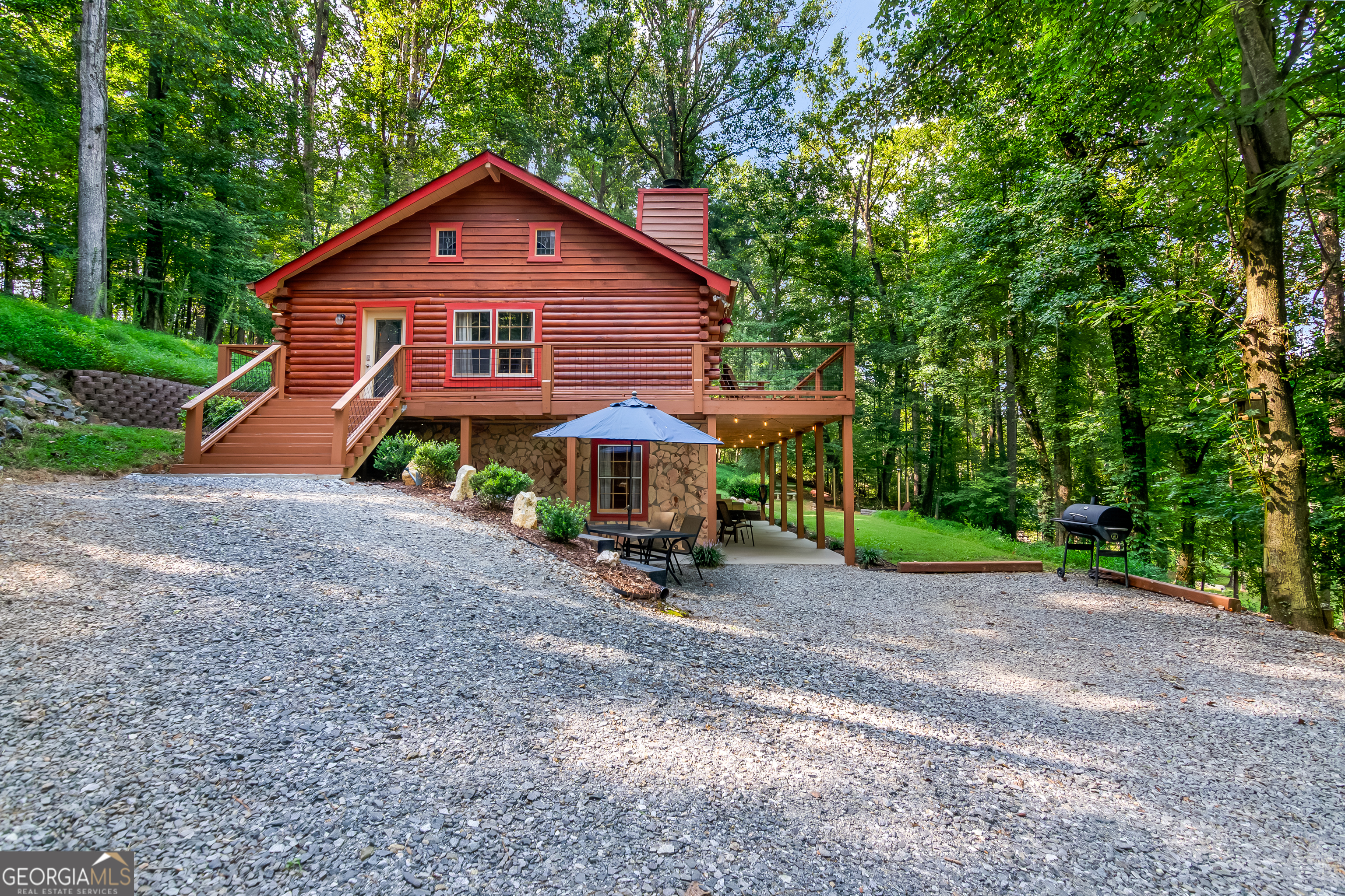 a view of a house with a yard and large trees