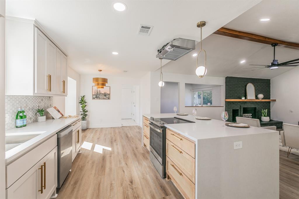 a kitchen that has a sink a stove and chairs