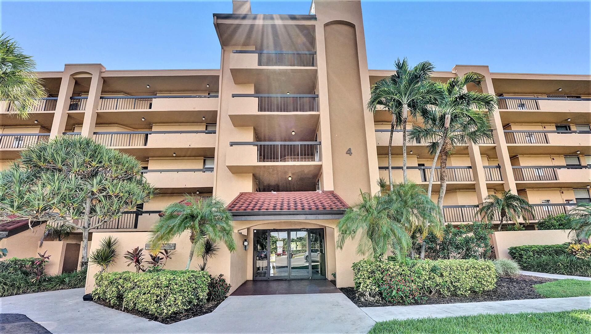 a front view of a multi story residential apartment building with a yard