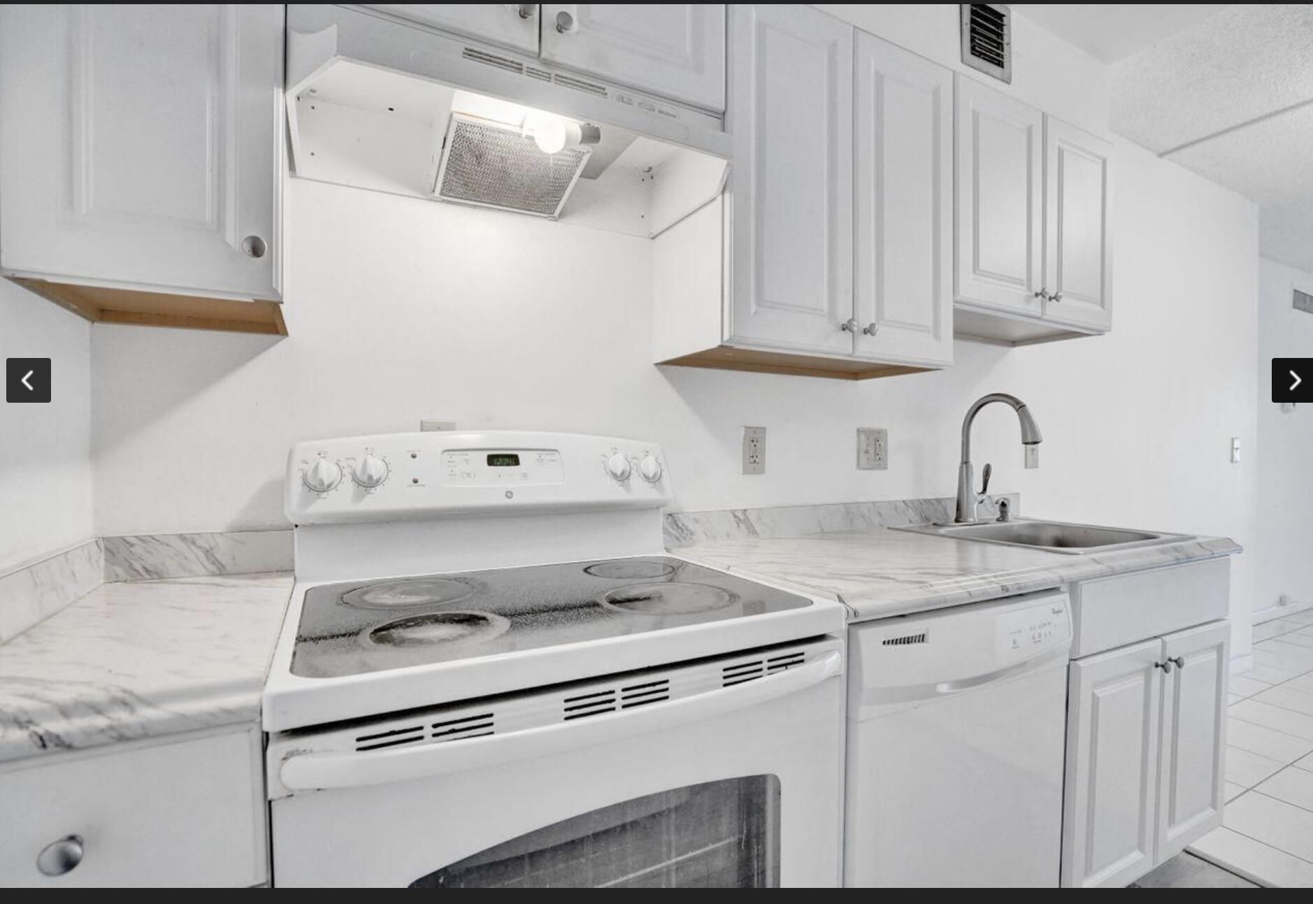 a white kitchen with sink and cabinets