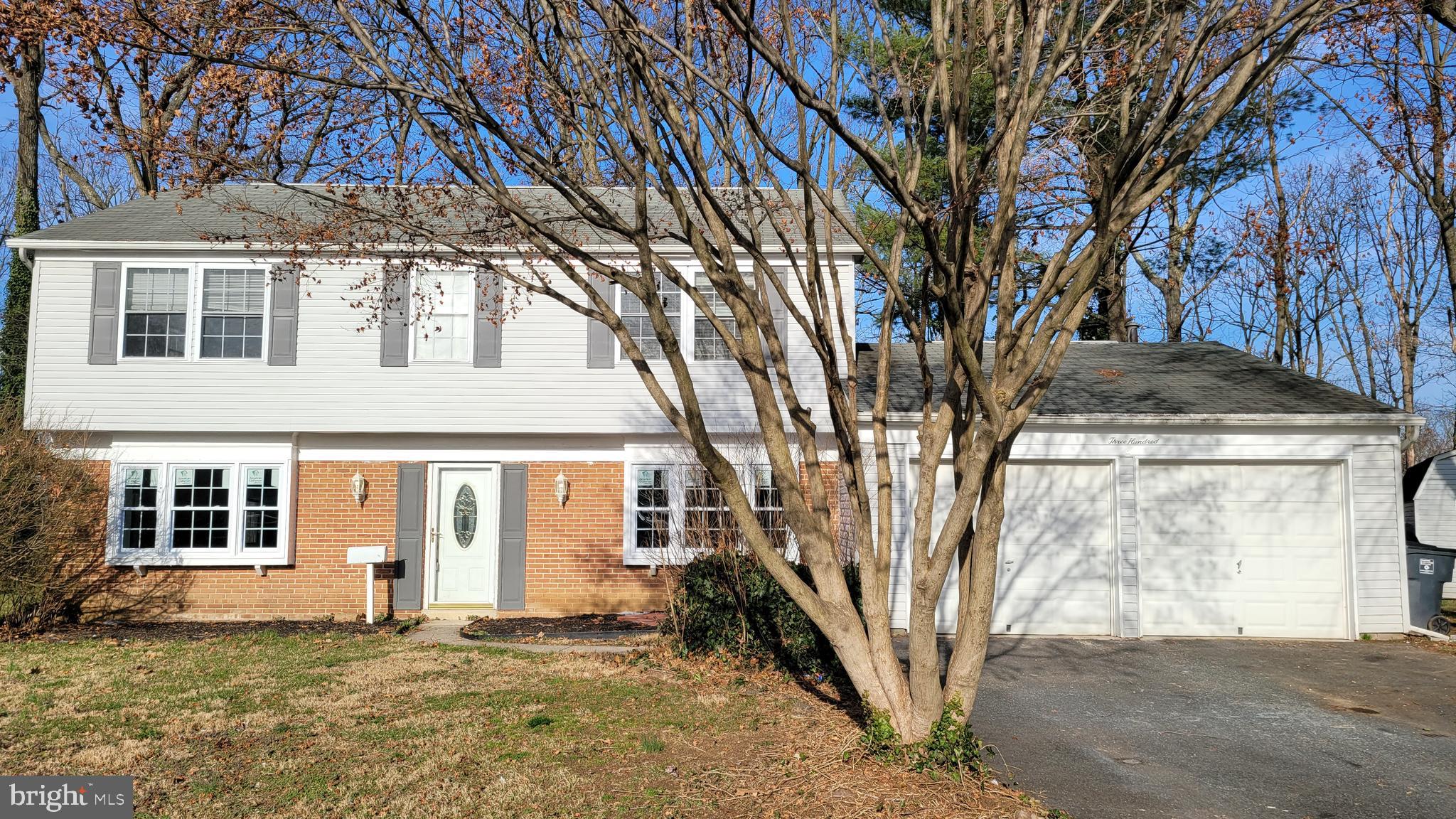 a front view of a house with a tree