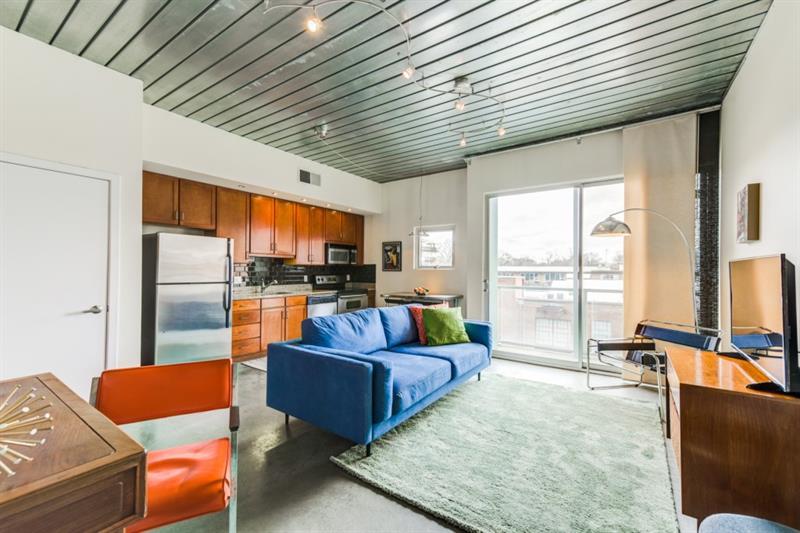 a living room with furniture kitchen view and a large window