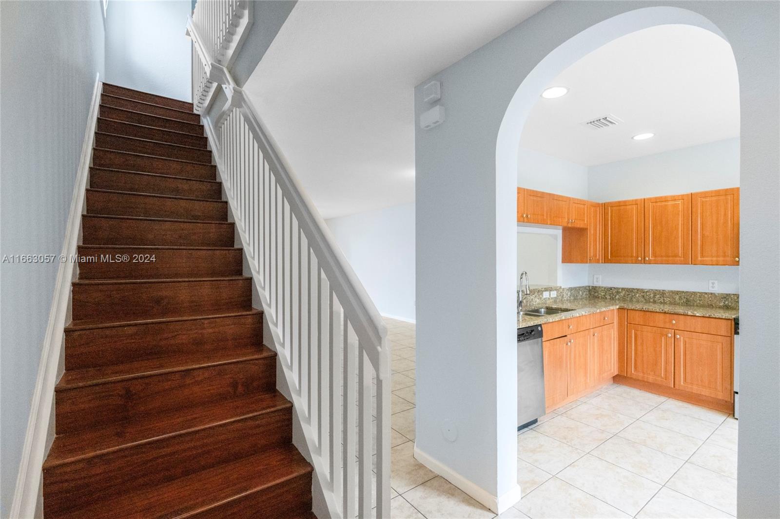 a view of a kitchen with wooden cabinets and entryway